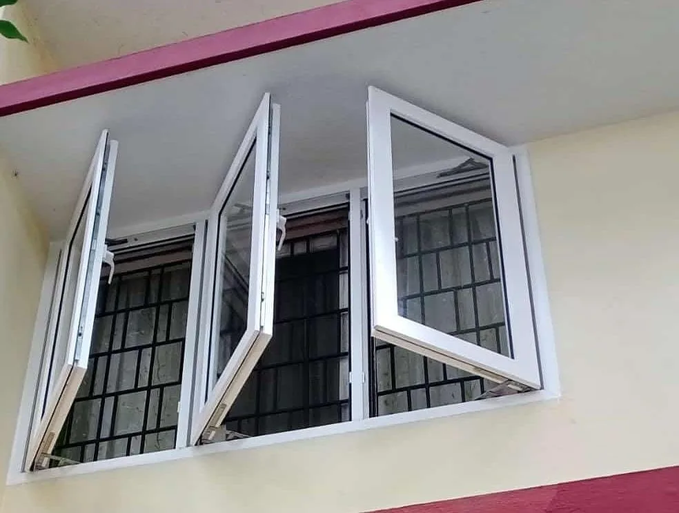 White uPVC casement windows opened outwards, with a black security grill fitted inside the window opening